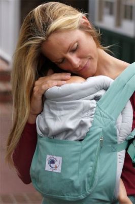 Mother holding baby with baby carrier